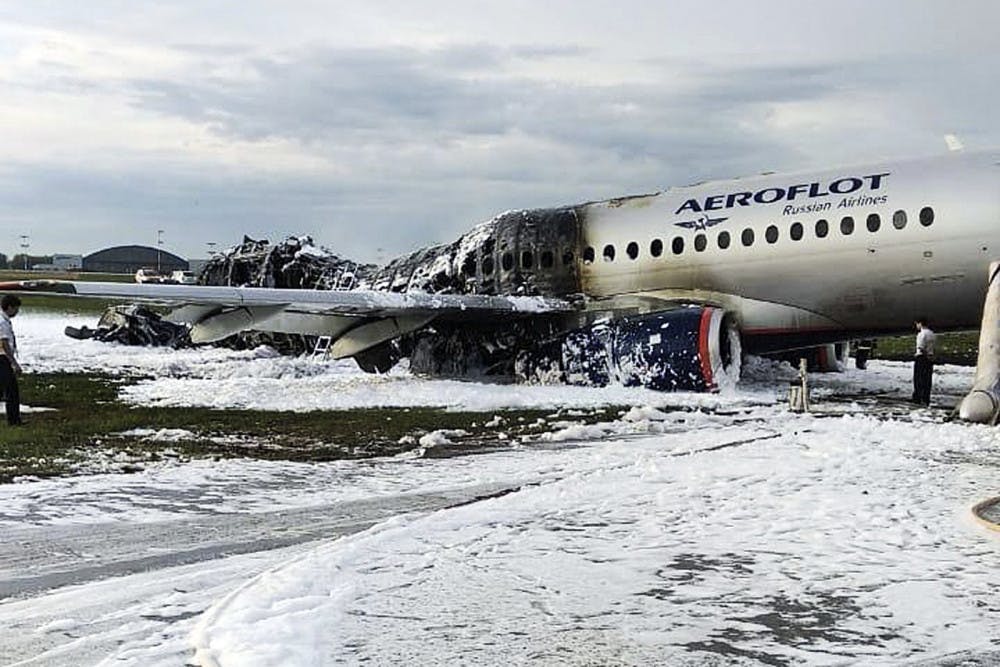 The Sukhoi SSJ100 aircraft of Aeroflot airlines is covered in fire retardant foam after an emergency landing in Sheremetyevo airport in Moscow, Russia, Sunday, May 5, 2019. Scores of people died when the Aeroflot airliner burst into flames while making the emergency landing at the airport Sunday evening, officials said.