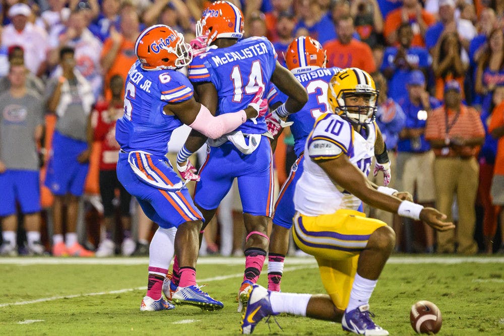 <p>Alex McCalister celebrates with Dante Fowler Jr. after a sack during Florida's 30-27 loss to LSU on Saturday at Ben Hill Griffin Stadium.</p>