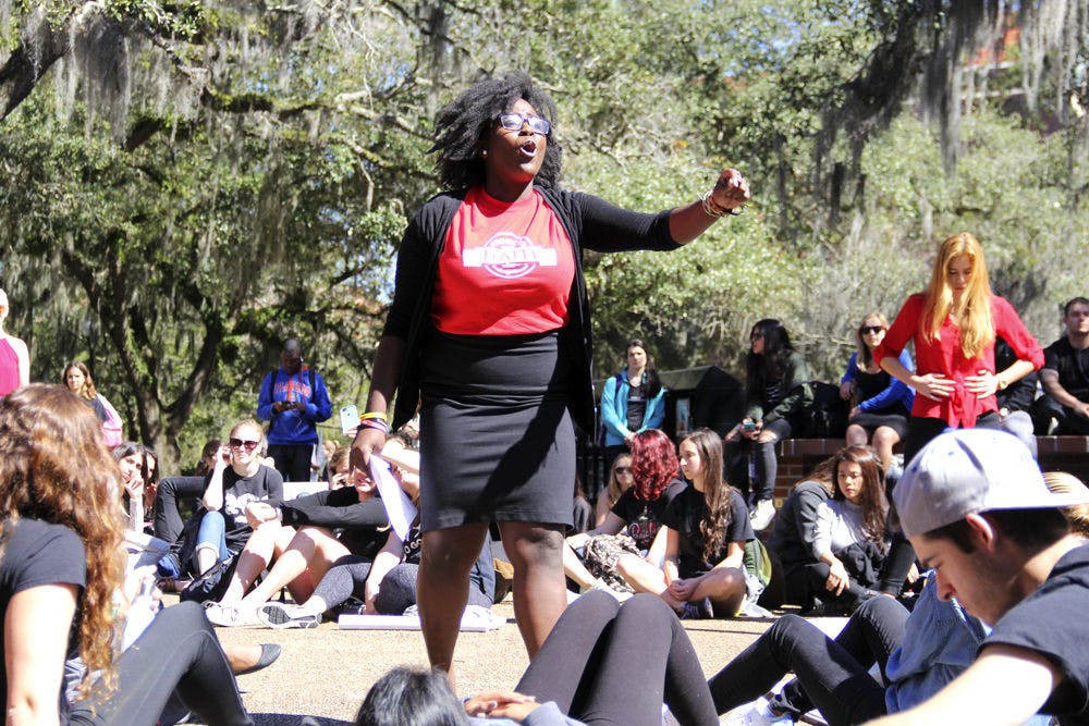 Bertrhude Albert leads the Global Awareness Flash Mob at Turlington Plaza on Tuesday. Participants froze in place for five minutes while other students shouted statistics on current issues in the world. Albert teaches a class of 200 students that focuses on heightening oral communication skills.