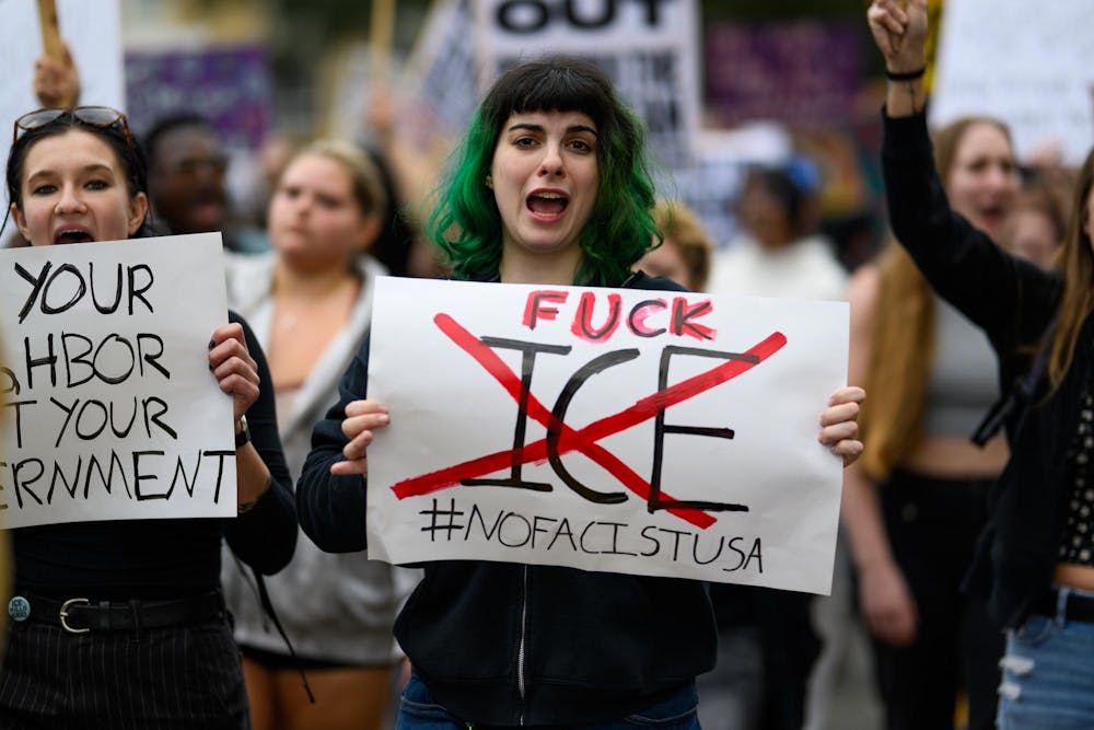 A demonstrator holds a sign during an ICE protest organized by YDSA, Friday, Jan. 30, 2026, along University Avenue in Gainesville, Fla.