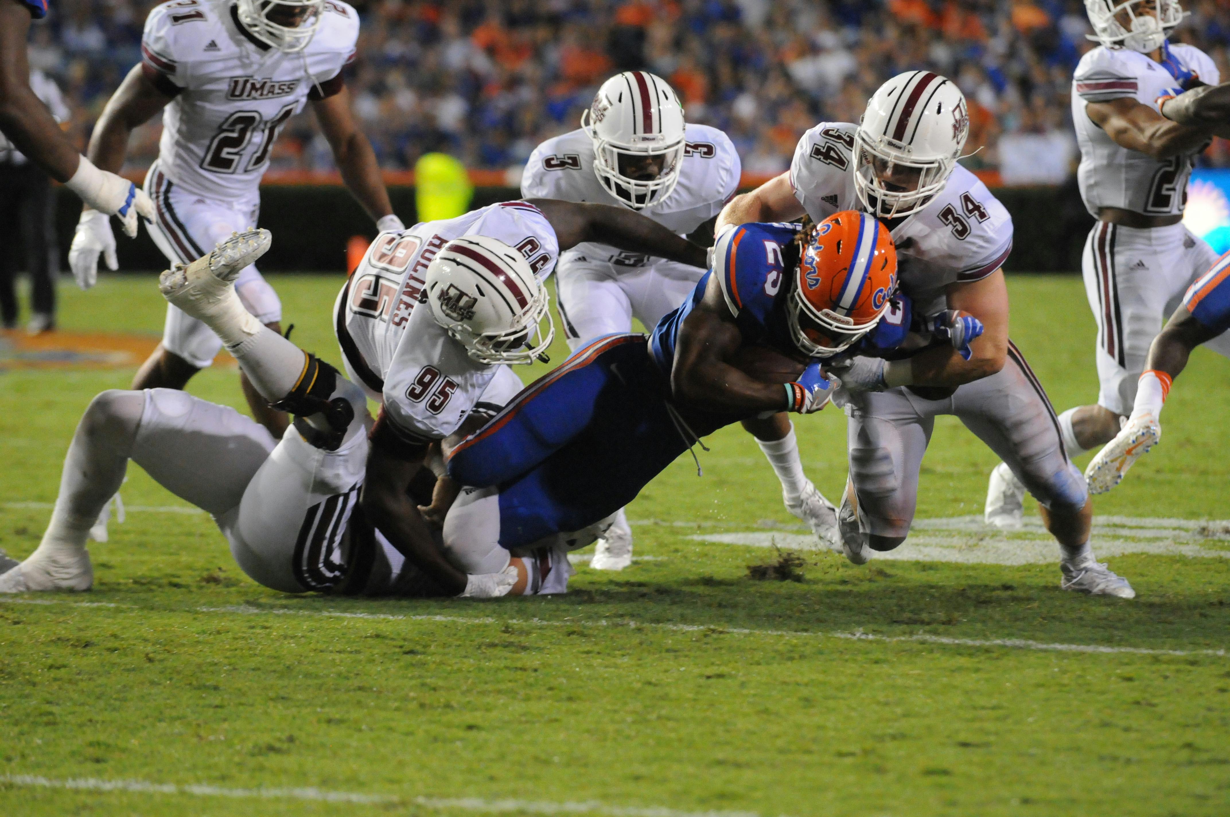 Jordan Scarlett (25) is tackled by UMass defenders during Florida's 24-7 win over Massachusetts on Sept. 3, 2016, at Ben Hill Griffin Stadium.