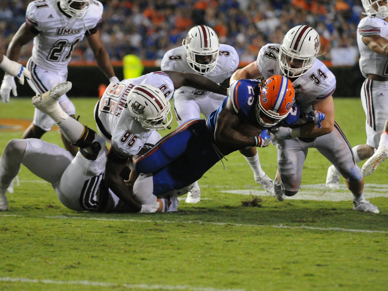 Jordan Scarlett (25) is tackled by UMass defenders during Florida's 24-7 win over Massachusetts on Sept. 3, 2016, at Ben Hill Griffin Stadium.