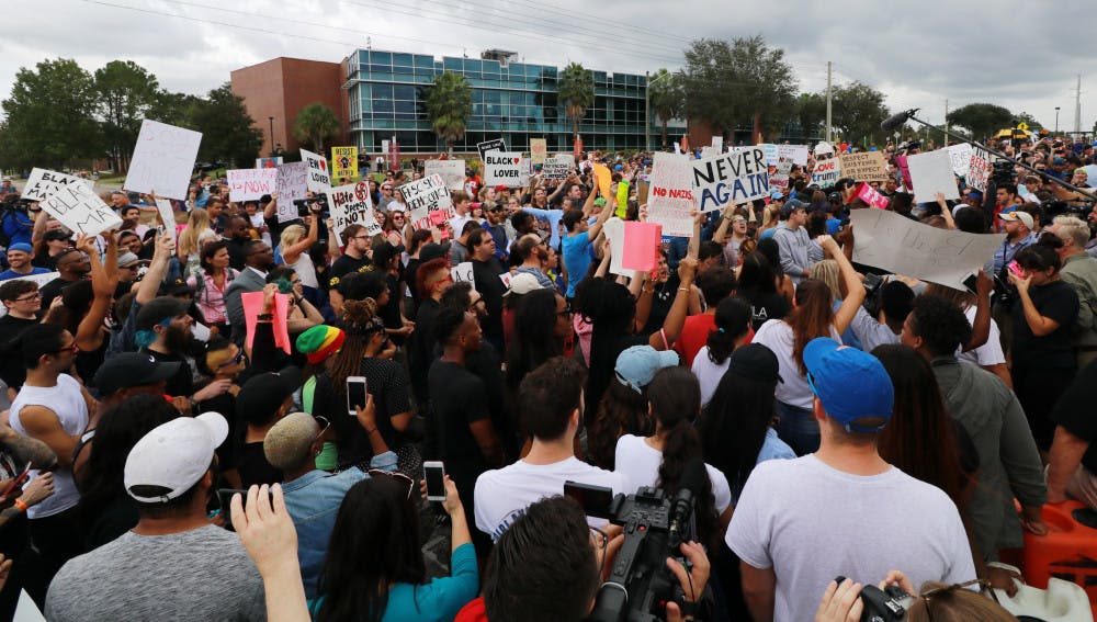 Hundreds of protesters yell, chant and display signs on their initial approach to the Phillips Center for the Performing Arts on Thursday.