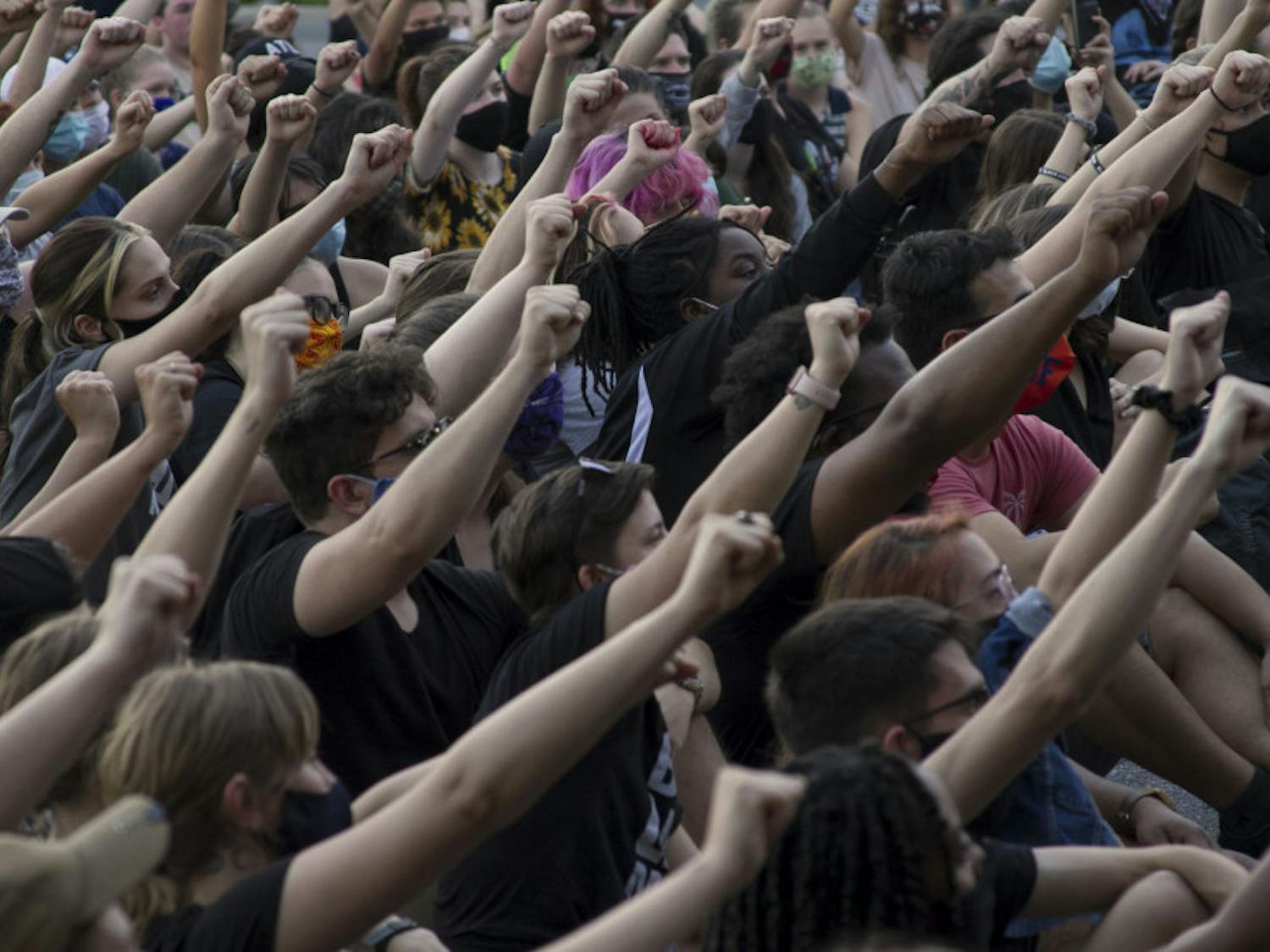 GoDDsville Dream Defenders use the stop at the Gainesville Police Department to announce a list of demands that the organization will present to local government officials. Hundreds of fists rise into the air as the crowd chants “No justice, no peace.”
