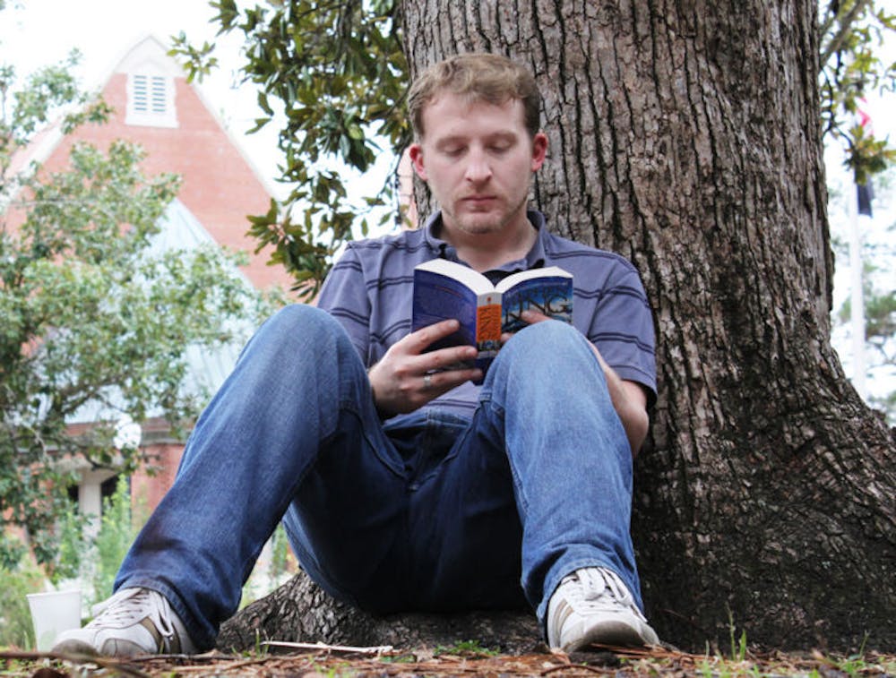 <p>Brendan Barraclough, a 23-year-old first-year medical physics graduate student, sits on the Plaza of the Americas and reads Stephen King’s “Dreamcatcher” Wednesday.</p>