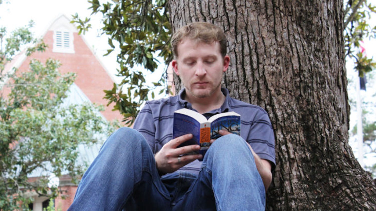 Brendan Barraclough, a 23-year-old first-year medical physics graduate student, sits on the Plaza of the Americas and reads Stephen King’s “Dreamcatcher” Wednesday.