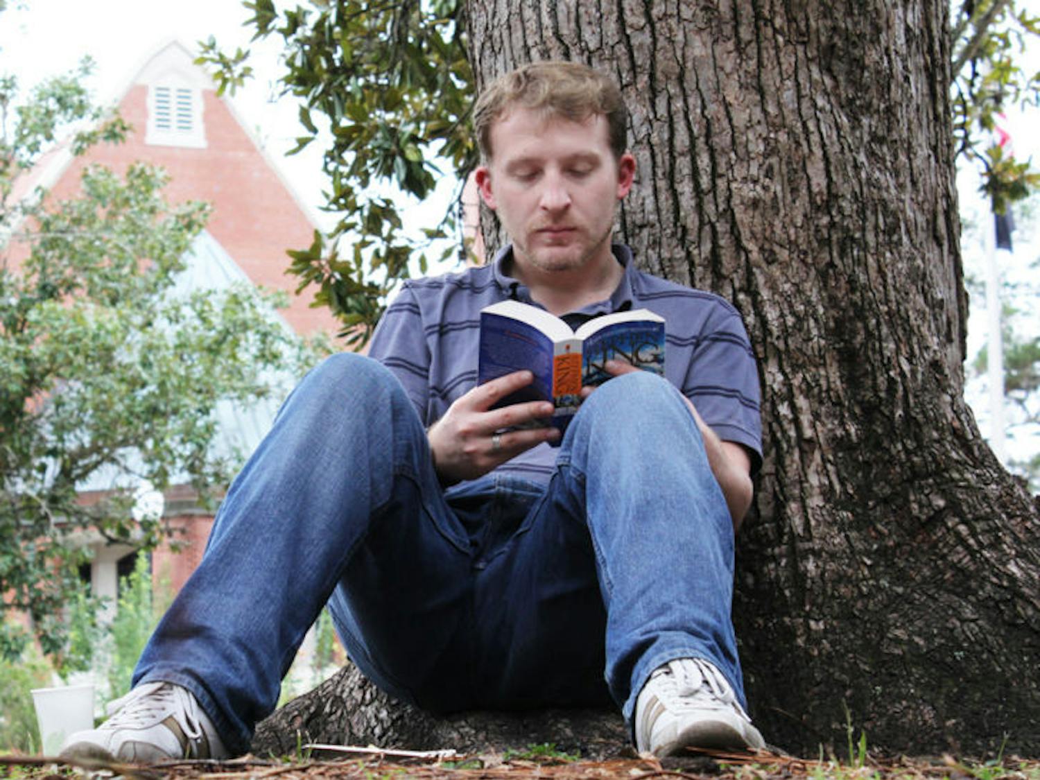 Brendan Barraclough, a 23-year-old first-year medical physics graduate student, sits on the Plaza of the Americas and reads Stephen King’s “Dreamcatcher” Wednesday.