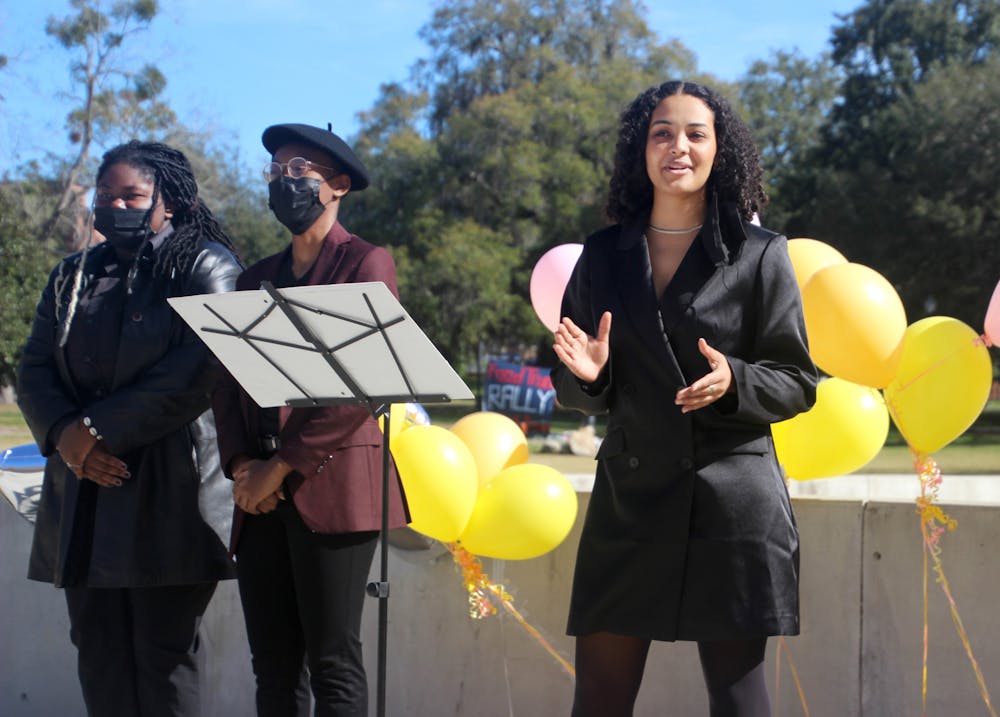 Gabrielle Adekunle (right), Change Party’s presidential nominee, addresses a crowd outside the Reitz Union North Lawn on Tuesday, Feb. 1. Beside her is Kenya Warner (left), treasurer nominee, and Dayanna Peek (middle), vice presidential nominee.