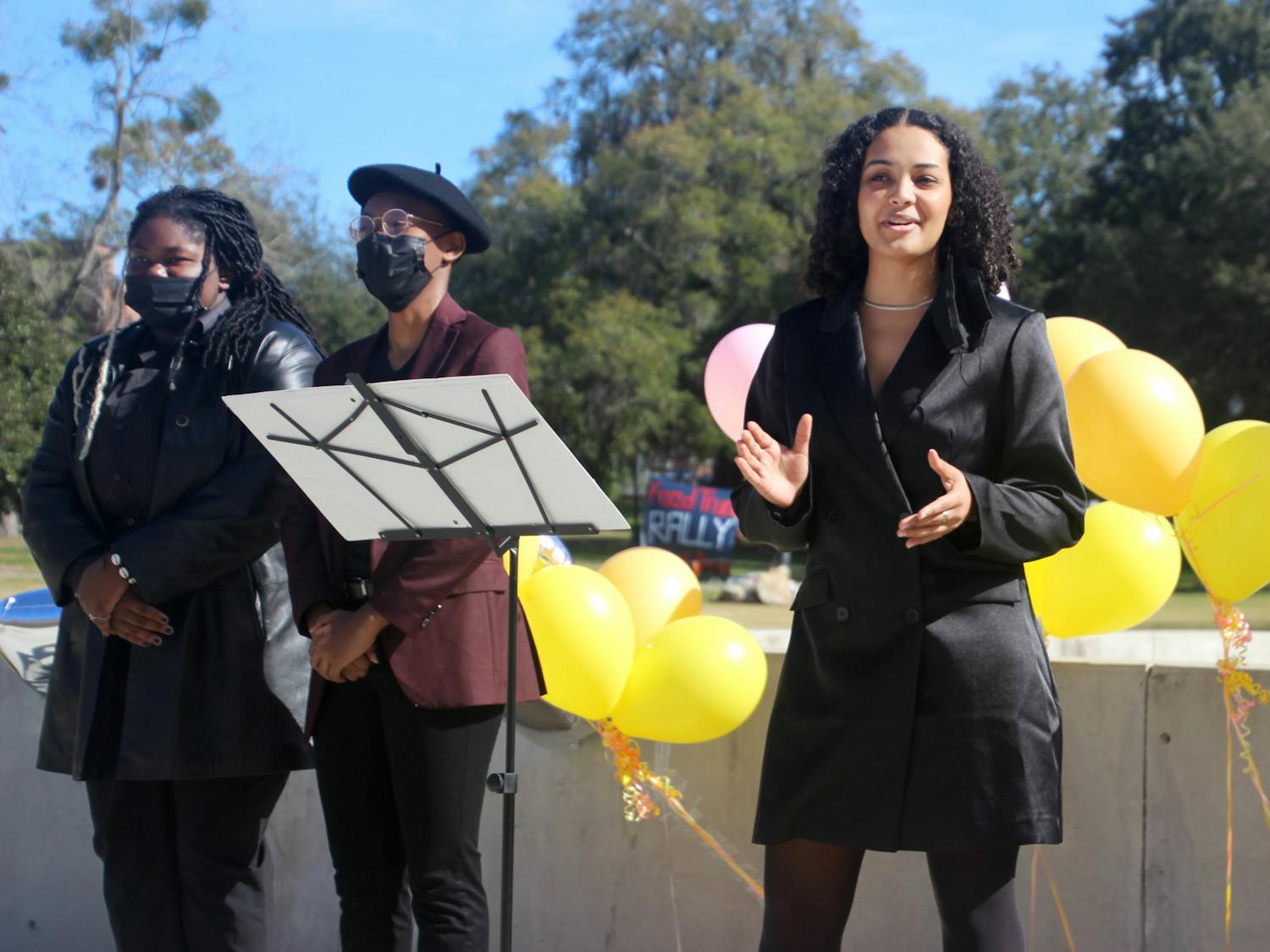 Gabrielle Adekunle (right), Change Party’s presidential nominee, addresses a crowd outside the Reitz Union North Lawn on Tuesday, Feb. 1. Beside her is Kenya Warner (left), treasurer nominee, and Dayanna Peek (middle), vice presidential nominee.