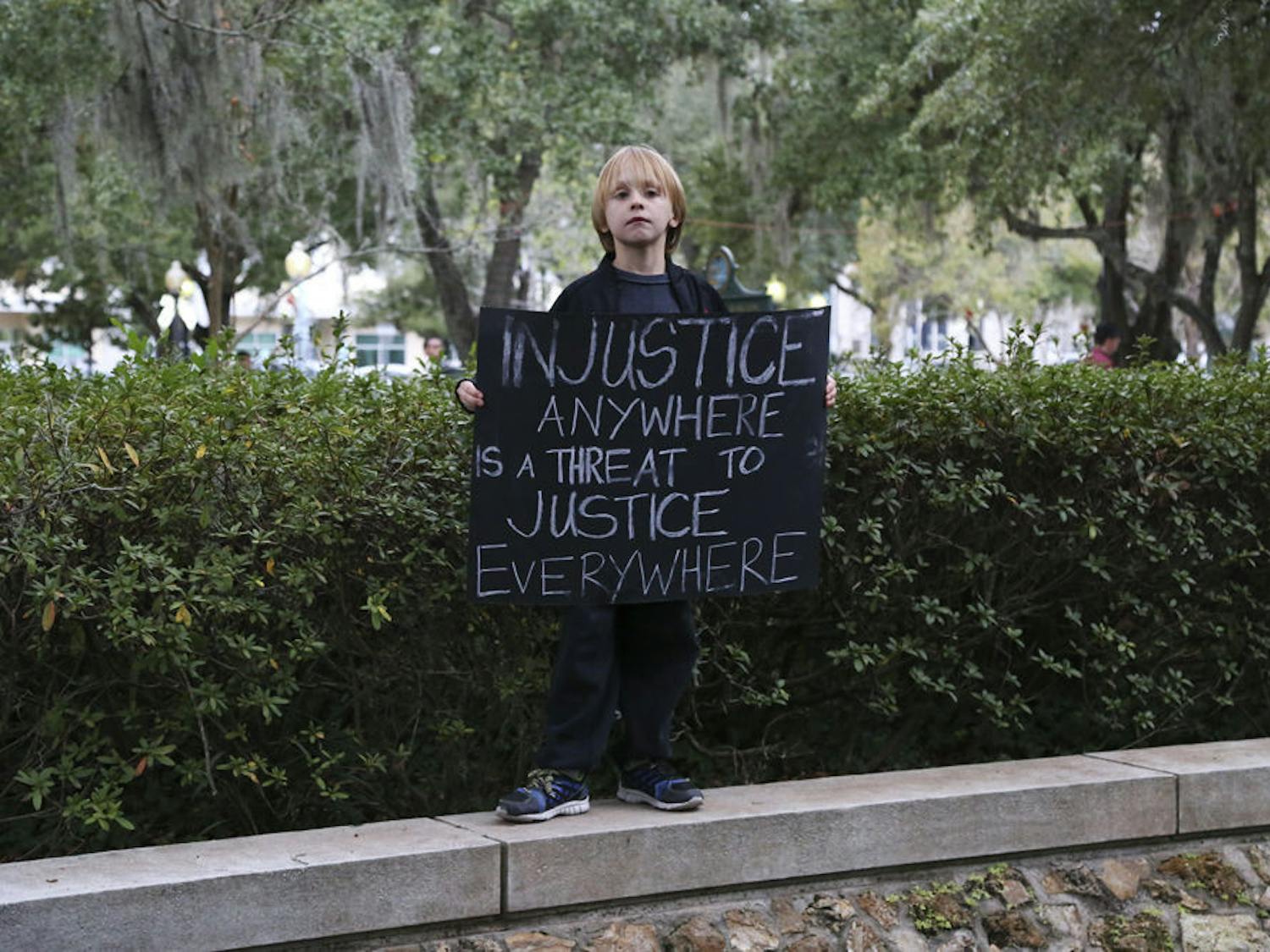 A little boy holds a sign up at the MLK Memorial Garden for the #BLACKLIVESMATTER march on Monday afternoon.
