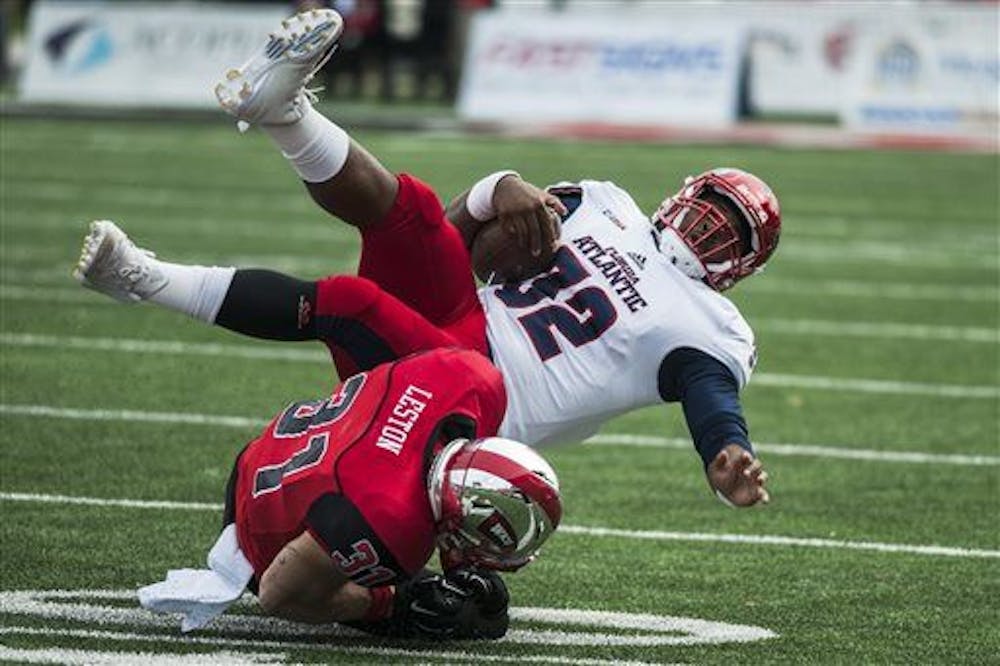 <p>Florida Atlantic quarterback Jaquez Johnson (32) is tackled by Western Kentucky defensive back Branden Leston (31) during an NCAA college football game, Saturday, Nov. 7, 2015, in Bowling Green, Ky. (Austin Anthony/Daily News via AP)&nbsp;</p>