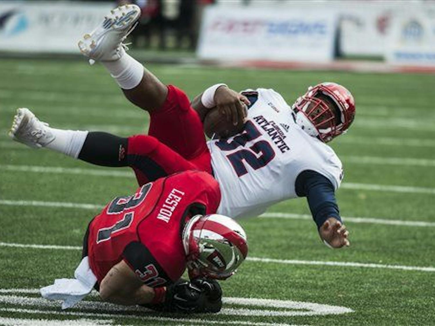 Florida Atlantic quarterback Jaquez Johnson (32) is tackled by Western Kentucky defensive back Branden Leston (31) during an NCAA college football game, Saturday, Nov. 7, 2015, in Bowling Green, Ky. (Austin Anthony/Daily News via AP) 