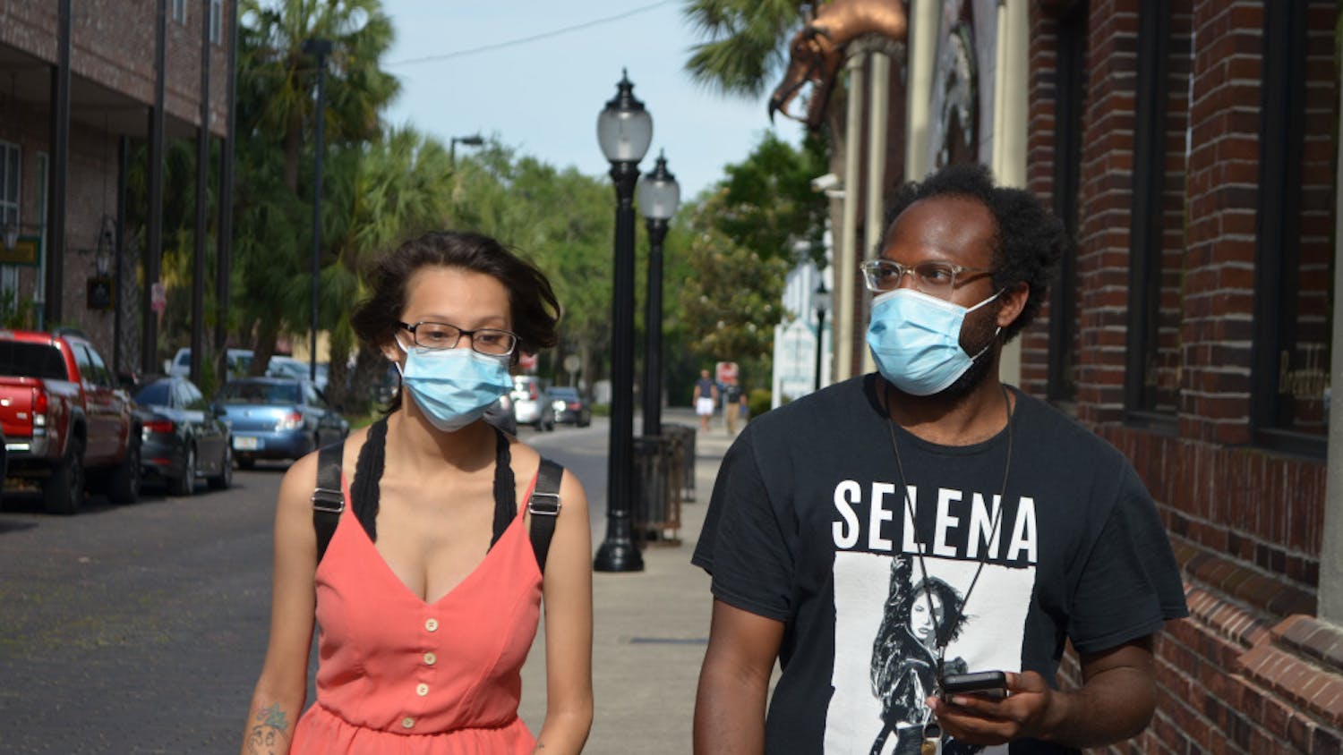 Denise Garcia and Jeffery Davis wear face masks in downtown Gainesville.