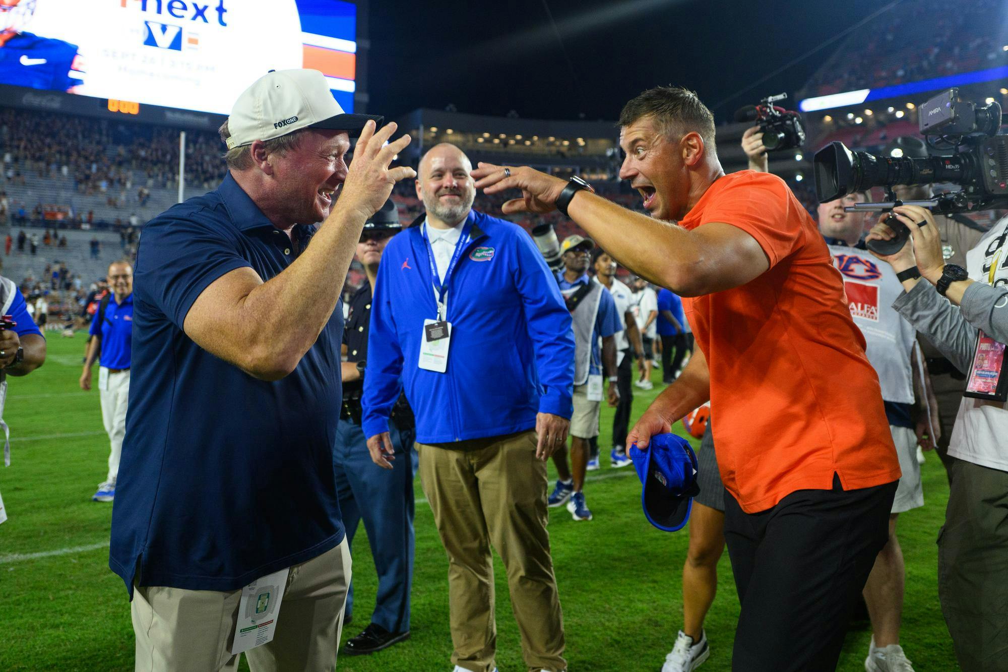 Florida head coach Jon Sumrall shakes hands with Jon Gruden after winning an NCAA college football game, Saturday, Sept. 19, 2026, in Auburn, Ala.