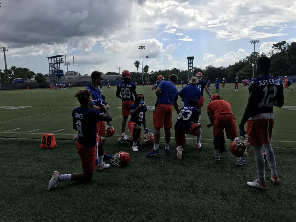 A unit of Florida wide receivers, including transfers Van Jefferson (12) and Trevon Grimes (8), rests during Day 1 of fall camp after catching passes from the quarterbacks.&nbsp;