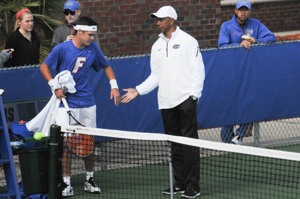 <p>UF coach Bryan Shelton (right) congratulates McClain Kessler during Florida's 6-1 win over Troy on Jan. 17, 2016, at the Ring Tennis Complex.</p>
