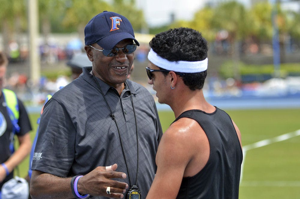 <p>UF coach Mike Holloway talks with Andres Arroyo during the Florida Relays on April 4, 2015, at the Percy Beard Track.</p>