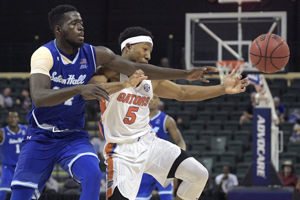 Seton Hall forward Ismael Sanogo, left, and Florida guard KeVaughn Allen (5) reach for the ball during the second half of an NCAA college basketball game in Lake Buena Vista, Fla., Thursday, Nov. 24, 2016. Florida won 81-76. (AP Photo/Phelan M. Ebenhack)