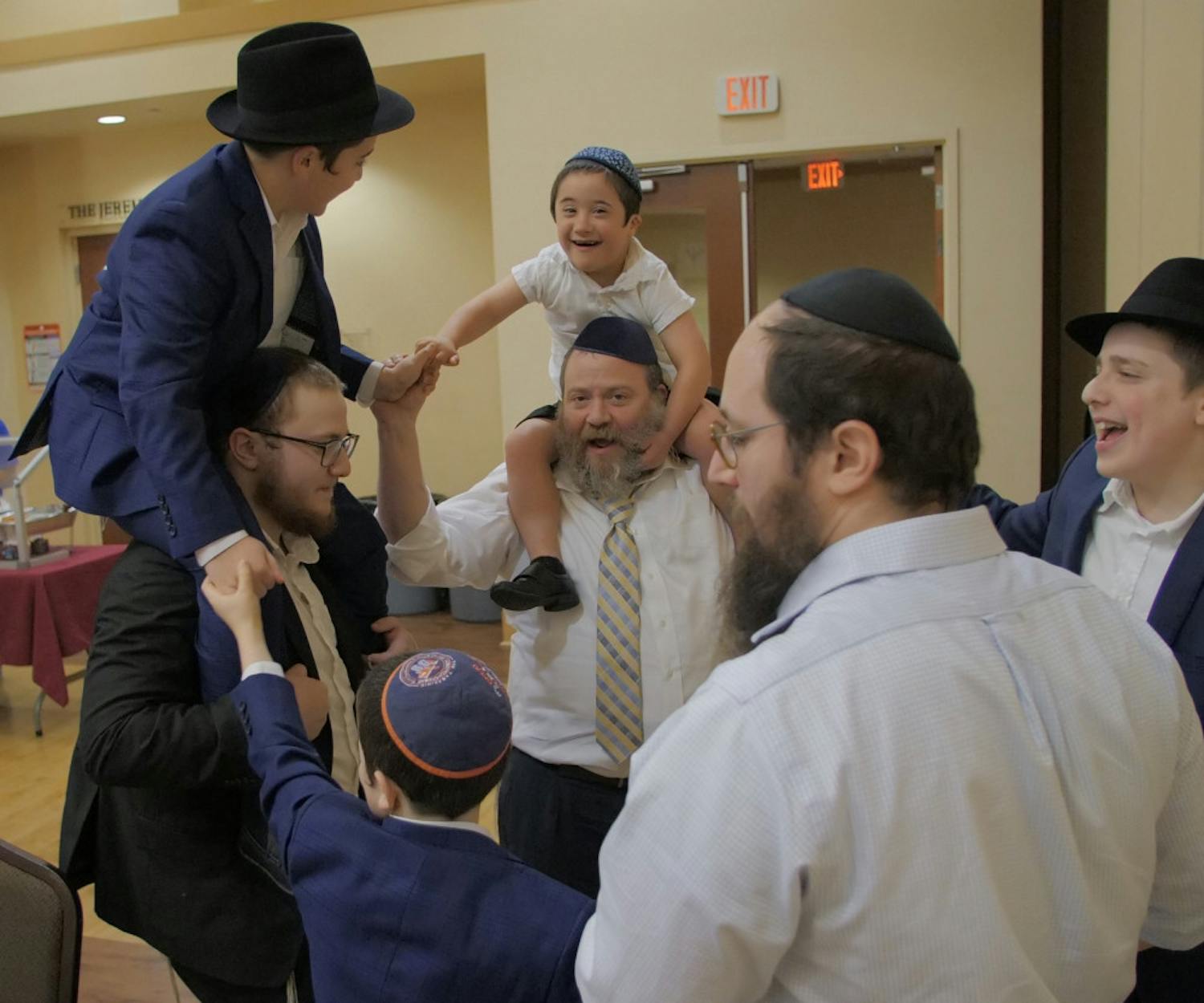 Shmueli Goldman, 13, and his relatives celebrate after he completes his recitation of Jewish law in both Yiddish and Hebrew. His family started dancing in a circle and continued dancing around the room.