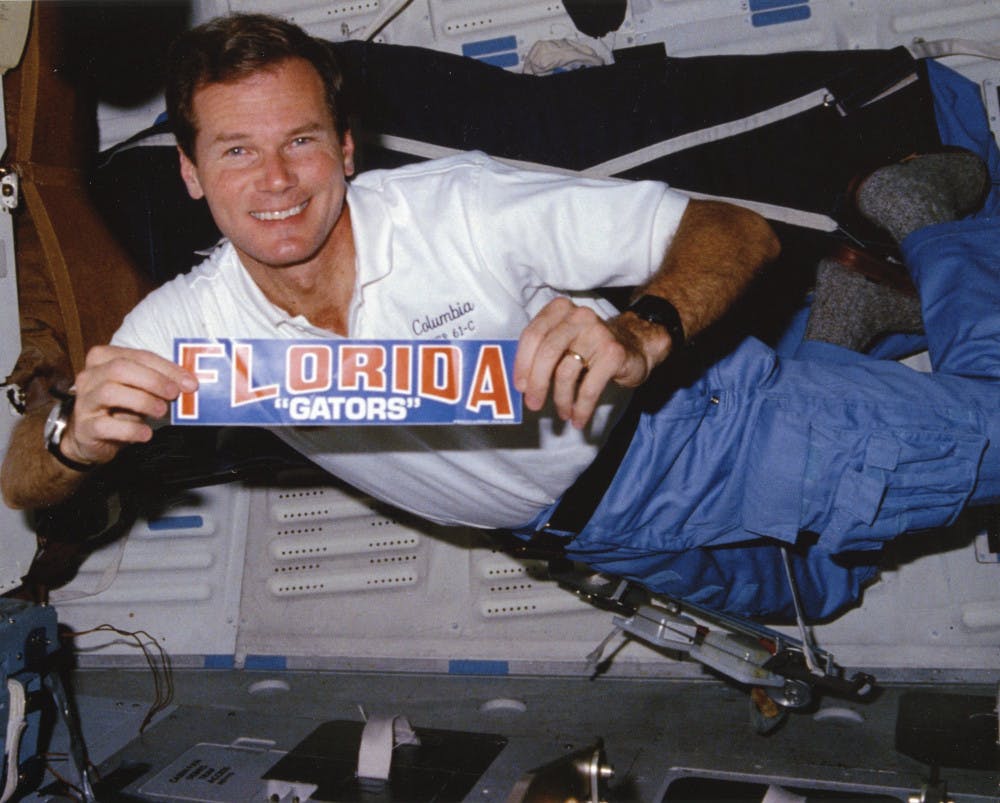Then-U.S. Rep. Bill Nelson aboard the Space Shuttle Columbia in 1986. This photo and the bumper sticker Nelson is holding in it are part of the collection of papers and other items he has deposited with UF’s Smathers Libraries.