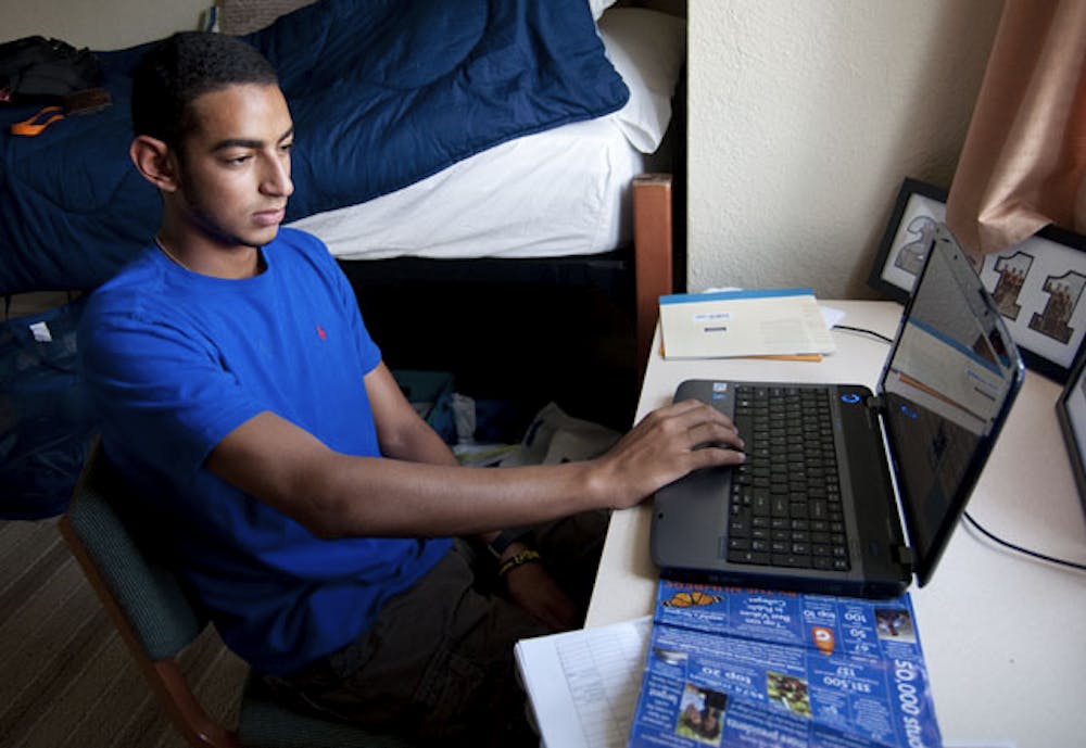 <p>Freshman business major David Habib, 18, checks his schedule on his laptop in his dorm after his first day of classes for the fall semester.</p>