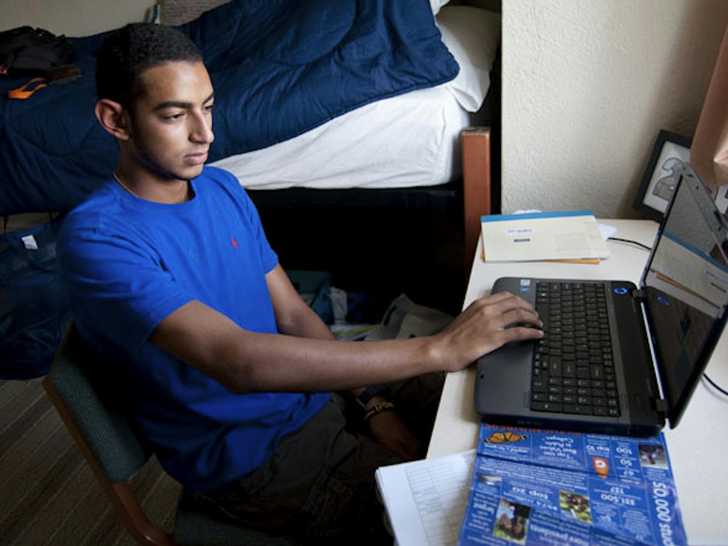 Freshman business major David Habib, 18, checks his schedule on his laptop in his dorm after his first day of classes for the fall semester.