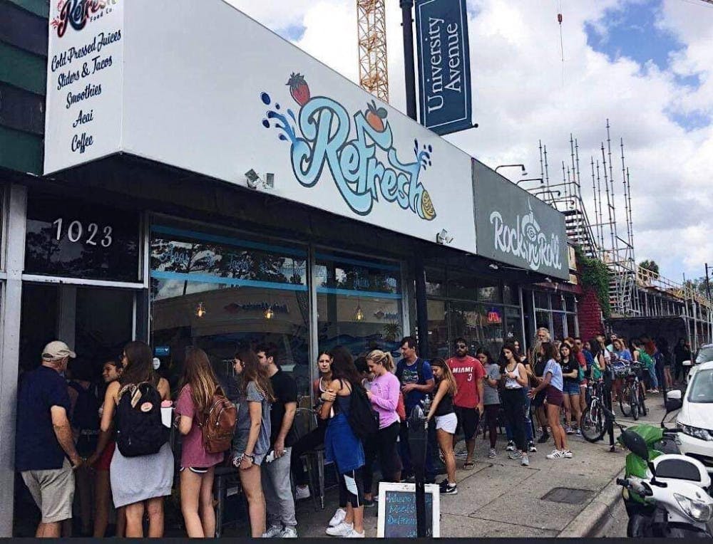 A line of customers wait to enter ReFresh Food Co. during their grand opening.