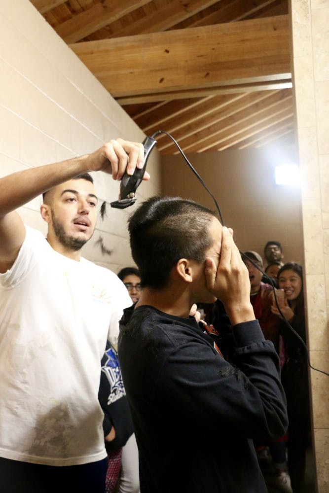 Artem Dadamyan, a 21-year-old UF biology junior, shaves the head of Felipe during Dare Night on Thursday night at Depot Park. Felipe had his head shaved first. Dadamyan, the organization president, then followed. “Hey! I’m kinda cute!” Felipe yelled when Dadamyan finished shaving. When more than their goal of $1,000 was raised, the two kept their promise to shave their heads.
&nbsp;