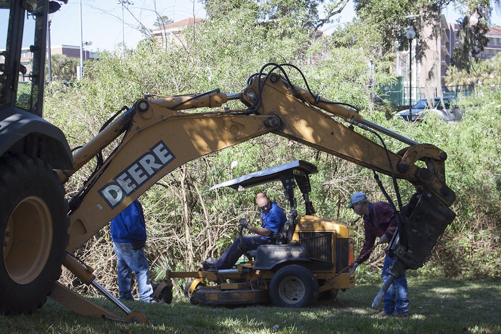 <p><span id="docs-internal-guid-1be99a35-d3e1-a42c-0d7a-c7b244506293"><span>A crew from the UF Physical Plant Division pulls a lawnmower out of a ditch after a worker fell into the ditch and injured his leg while mowing grass by Museum Road on Tuesday. Physical Plant Division workers watching the lawnmower get pulled from the ditch said they know and work with the man who was injured.</span></span></p>