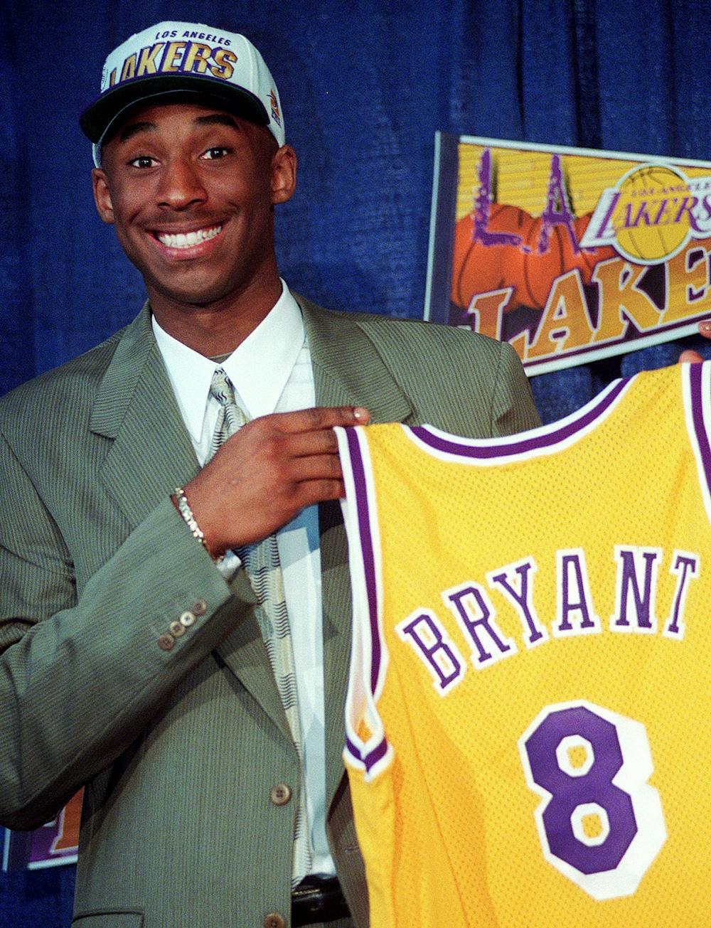 <p>FILE - In this July 12, 1996, file photo Kobe Bryant, 17, jokes with the media as he holds his Los Angeles Lakers jersey during a news conference at the Great Western Forum in Inglewood, Calif. Bryant, a five-time NBA champion and a two-time Olympic gold medalist, died in a helicopter crash in California on Sunday, Jan. 26, 2020. (AP Photo/Susan Sterner, File)</p>