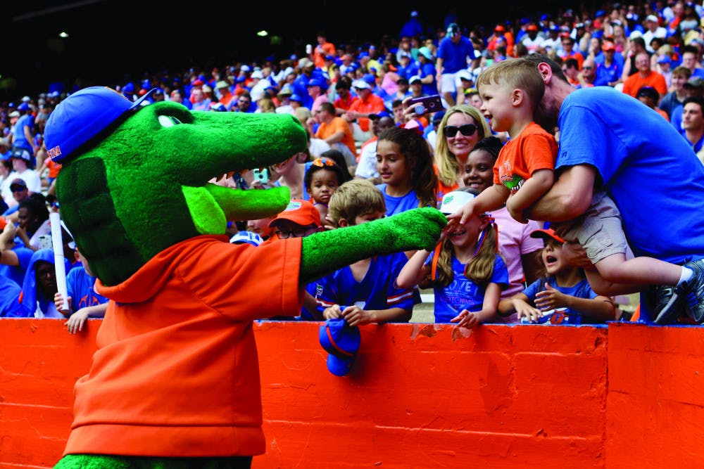 <p id="docs-internal-guid-b87d38a6-7fff-3cfa-8156-748943837e52" dir="ltr"><span>Albert E. Gator greets a young Gator fan during the Orange &amp; Blue football game in January 2019. The scrimmage held at Ben Hill Griffin Stadium had 53,015 in attendance.</span></p>