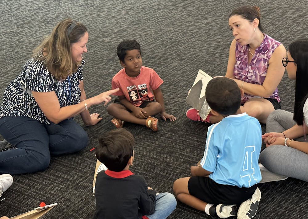 <p>Volunteers with the Latina Women’s League (left, upper right) sit down to read “¿De quién eres, ratóncito?” at the Tower Road Public Library on Saturday, Oct. 21, 2023. Voluntarios de la Liga de Mujeres Latinas (izquierda, arriba a la derecha) se sientan a leer “¿De quién eres, ratóncito?” en la biblioteca pública de Tower Road el 21 de octubre de 2023.</p>