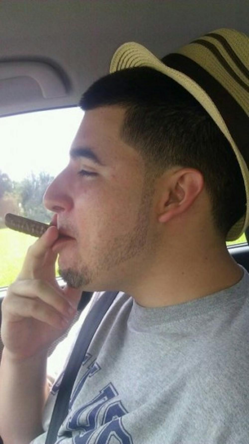 <p>Derik Alonso jokingly "pretends to be Cuban" with a fedora hat and Twix "cigar."</p>