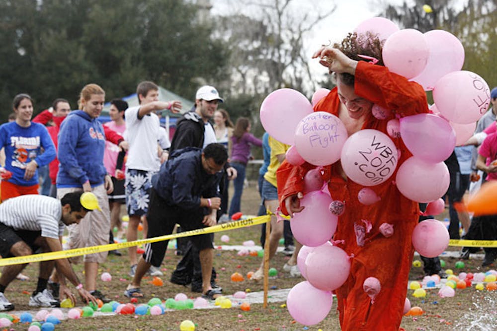 <p>Patrick Wanninkhof shields himself from water balloons at the World's Largest Water Balloon Fight against Breast Cancer at Flavet Field in February 2010.</p>