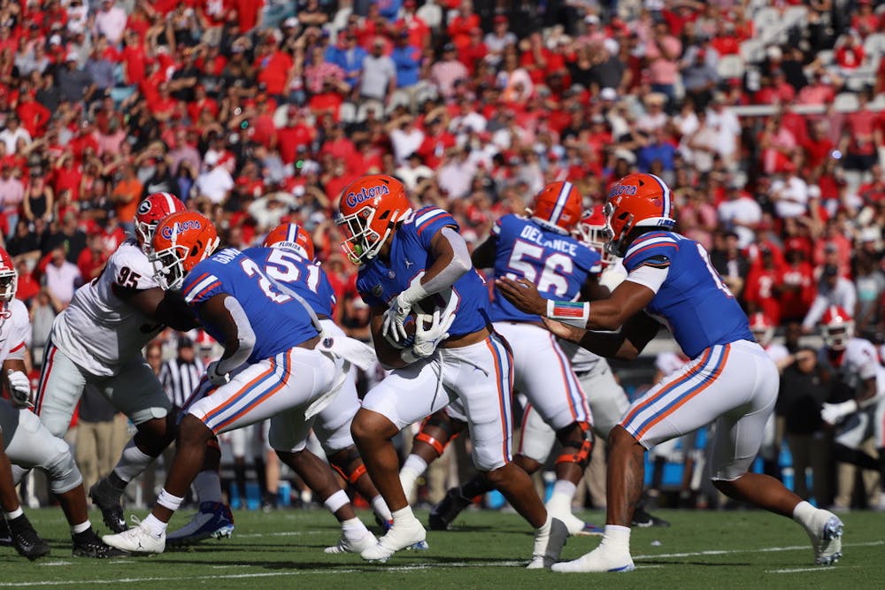 Gators running back Malik Davis (pictured with ball) takes a handoff from quarterback Anthony Richardson during Florida's Oct. 30 game against Georgia.