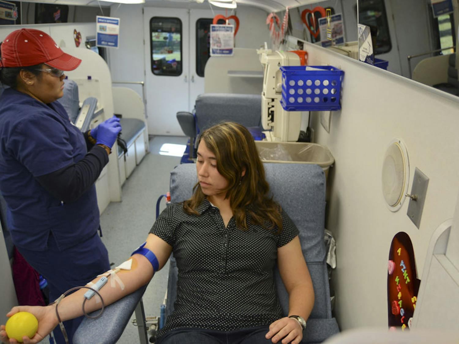 Mandy Moss, a 20-year-old UF mechanical and aerospace engineering junior, squeezes a stress ball as she donates blood in one of the LifeSouth buses on the Reitz Union North Lawn on Monday afternoon. UF is competing against the University of Kentucky to see who can collect the most blood as part of LifeSouth’s “What Colors Do You Bleed?” blood drive.