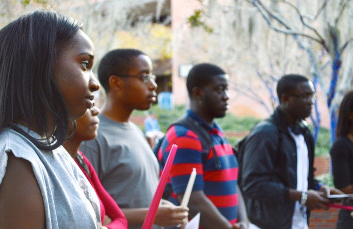 Shawama Jean-Gilles, 20, Sarasha Guillaume, 19, and Roldyne Dolce, 18, look onto a ceremony honoring Haitian earthquake victims. Monday marked the four-year anniversary of the disaster. Read the story on page 5.