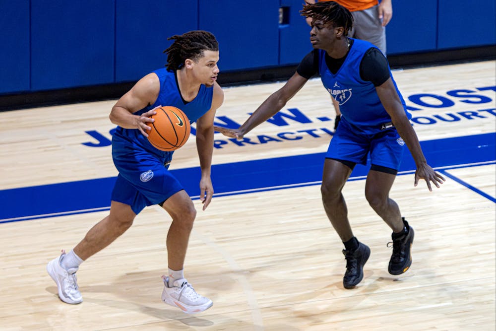 Junior guard Walter Clayton dribbles the ball against sophomore guard Denzel Aberdeen in Florida's open practice on Tuesday, Sept. 26, 2023.