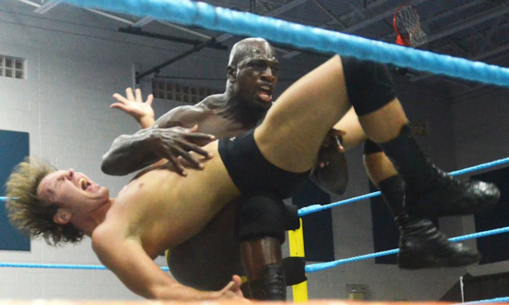 <p>Titus O'Neil, whose real name is Thaddeus Bullard, hits Dean Ambrose with a back breaker at FCW Summer Slamarama at the Martin Luther King Jr. Multipurpose Center Friday.</p>