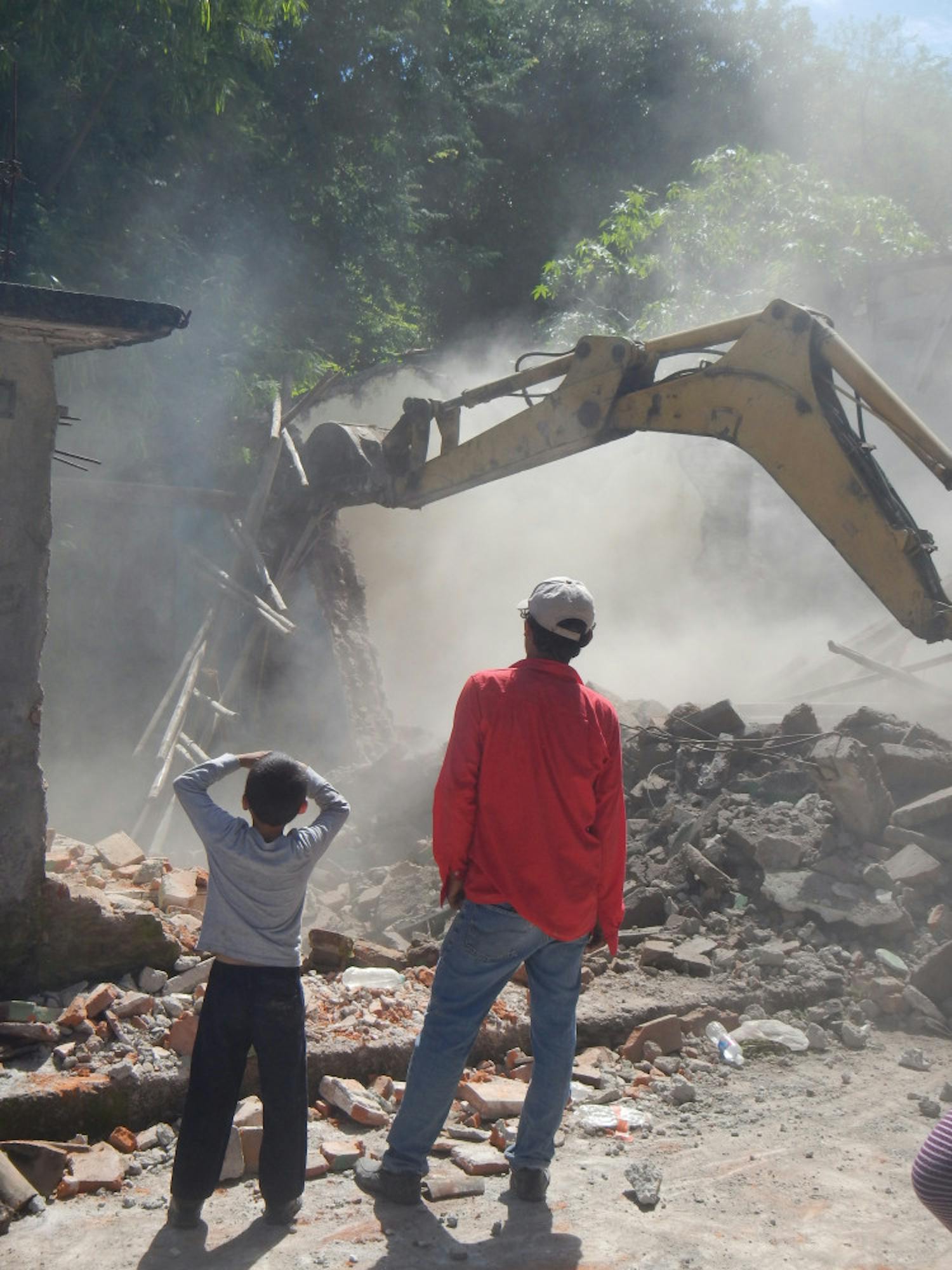 A father and son watch their damaged home being demolished in the village of Contla, Mexico.