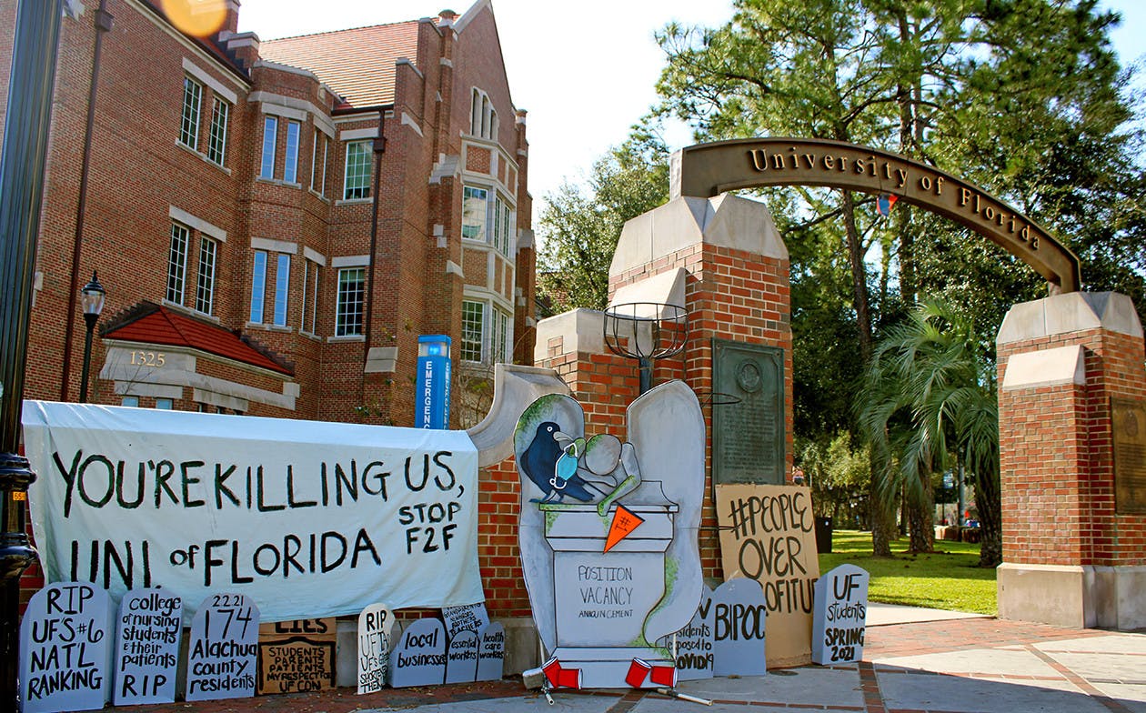 A collection of tombstone shaped signs and a banner calling for the end of in-person classes at the University of Florida was set-up on the corner of 13th Street and University Avenue on Thursday, Feb. 4, 2021. 