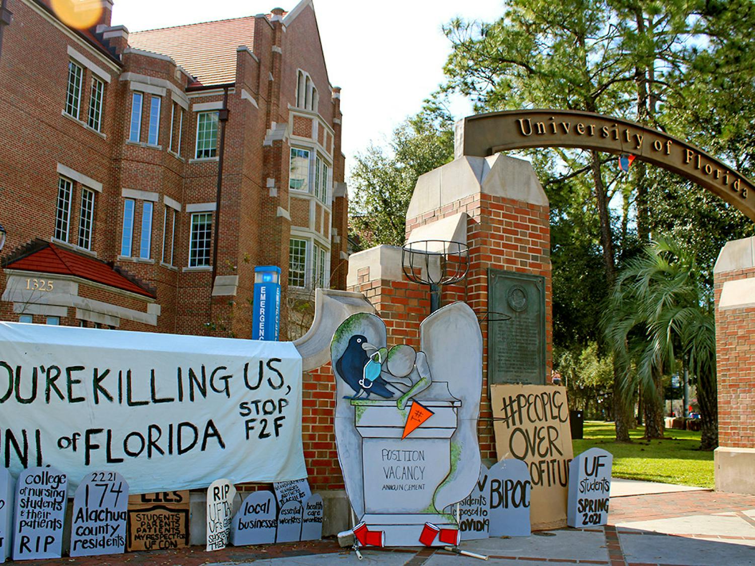 A collection of tombstone shaped signs and a banner calling for the end of in-person classes at the University of Florida was set-up on the corner of 13th Street and University Avenue on Thursday, Feb. 4, 2021.