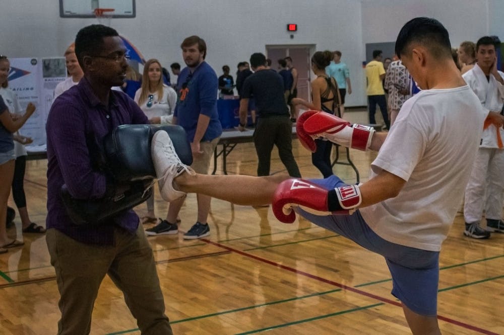 Yeneneh Terefe, a 34-year-old historic preservation graduate student, and Will Tang, a 5th year civil engineering student, spar Aug. 22 at RecStravaganza. Terefe has practiced kickboxing and judo for about eight years. Tang was president of Kickboxing Club last year and has practiced kickboxing for about six years.&nbsp;