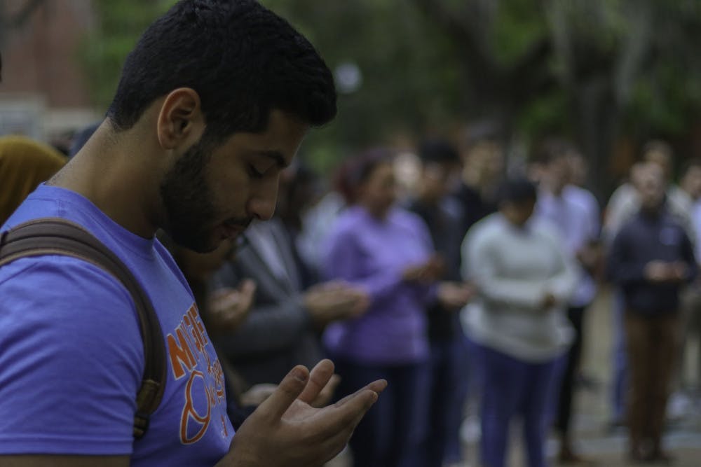 Ibrahim Ragab, a 21-year-old biology senior, closes his eyes Monday during a moment of prayer at a memorial for the victims of the New Zealand mosque shootings. “I’m Muslim and I wanted to empathize with my fellow Muslim brothers and sisters who have lost their lives in such a tragic way,” he said. 