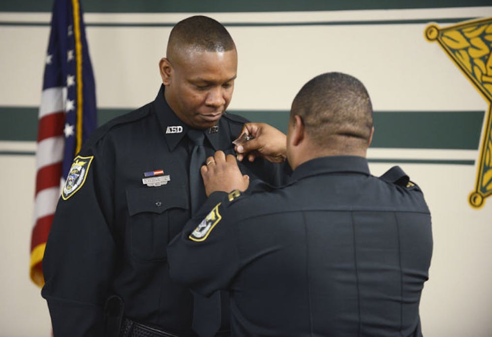 <p>Detention Deputy Michael McClenton’s badge is pinned on his uniform during an oath of office ceremony held at the Alachua County Sheriff’s Office on Thursday.</p>