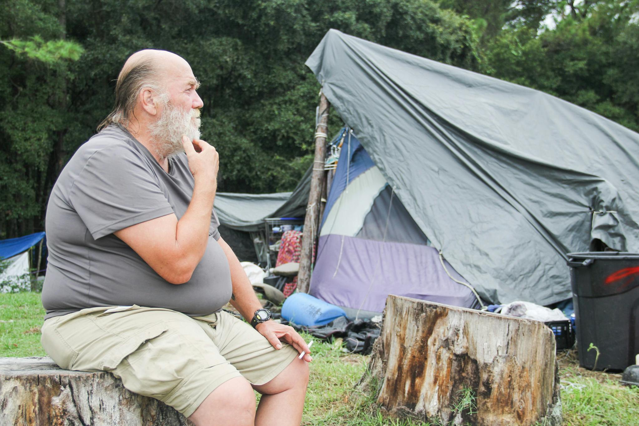 Mick Burnette, a Vietnam War veteran, smokes a cigarette before the rain begins to fall at Dignity Village on Sept. 1, 2016.