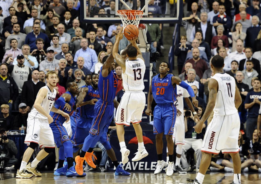 <p>Connecticut's Shabazz Napier (13) goes up for the game winning basket at the buzzer during its 65-64 win against Florida on Monday in Storrs, Conn.</p>