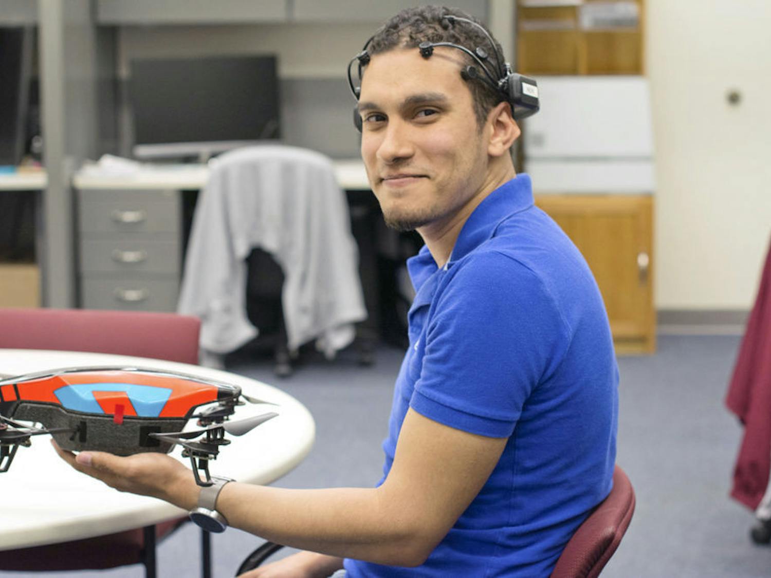 Marvin Andujar, a 25-year-old UF human-centered computing doctoral student, poses for a photo with a mind-controlled drone that he and his partner, Chris Crawford, programmed.