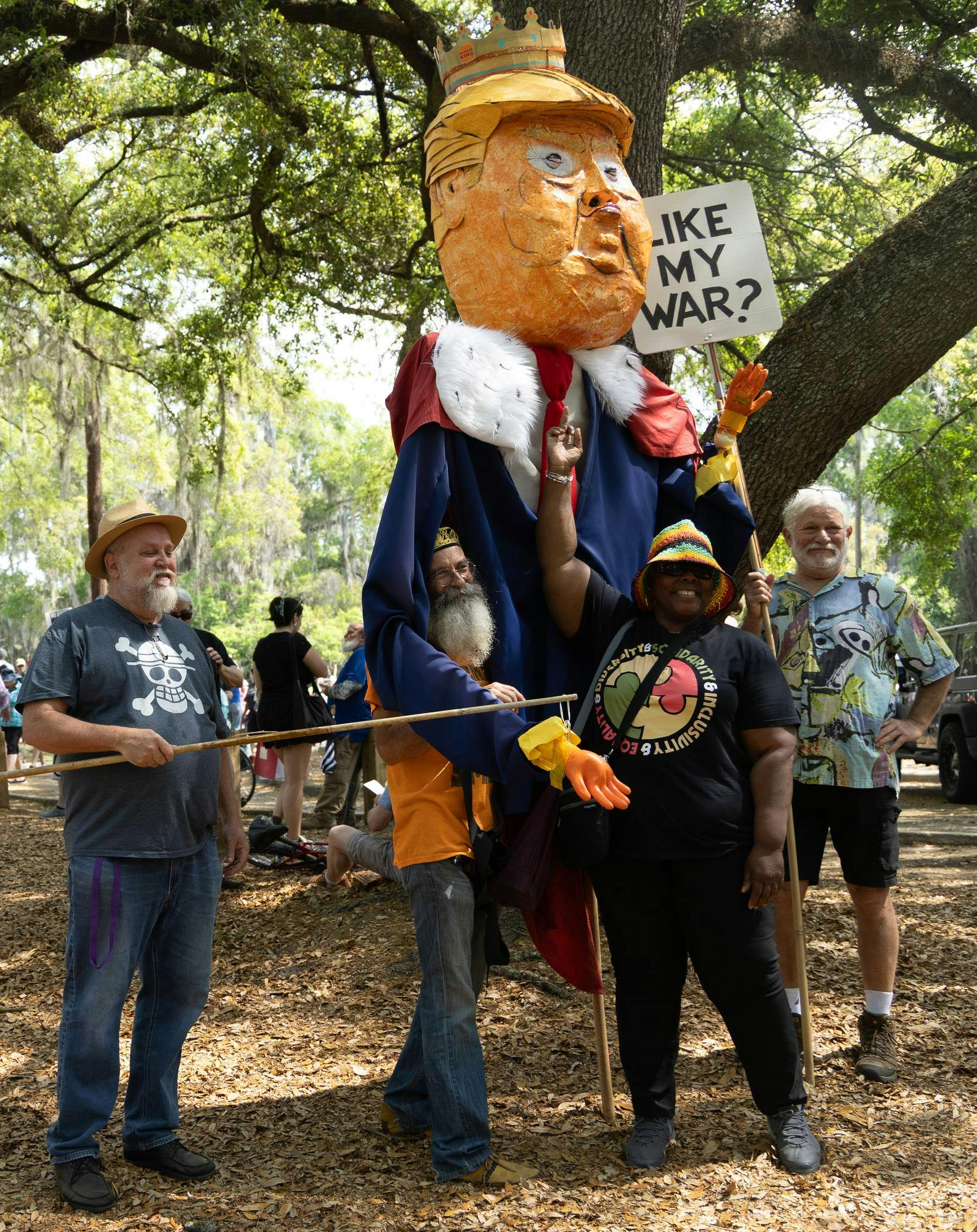Attendees of the No Kings Protest at Cora P. Roberson Park pose with a puppet of Donald Trump dressed in King attire, Saturday, March 28, 2026, in Gainesville, Fla. 