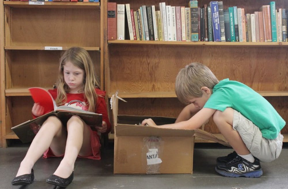 <p>“I wish I had a million books,” said Lily Mills, 7, before she sat with her brother Hayden, 5, at the Friends of the Library book sale. The sale, which started Saturday and ends Wednesday, raises money for the Alachua County Library District.</p>